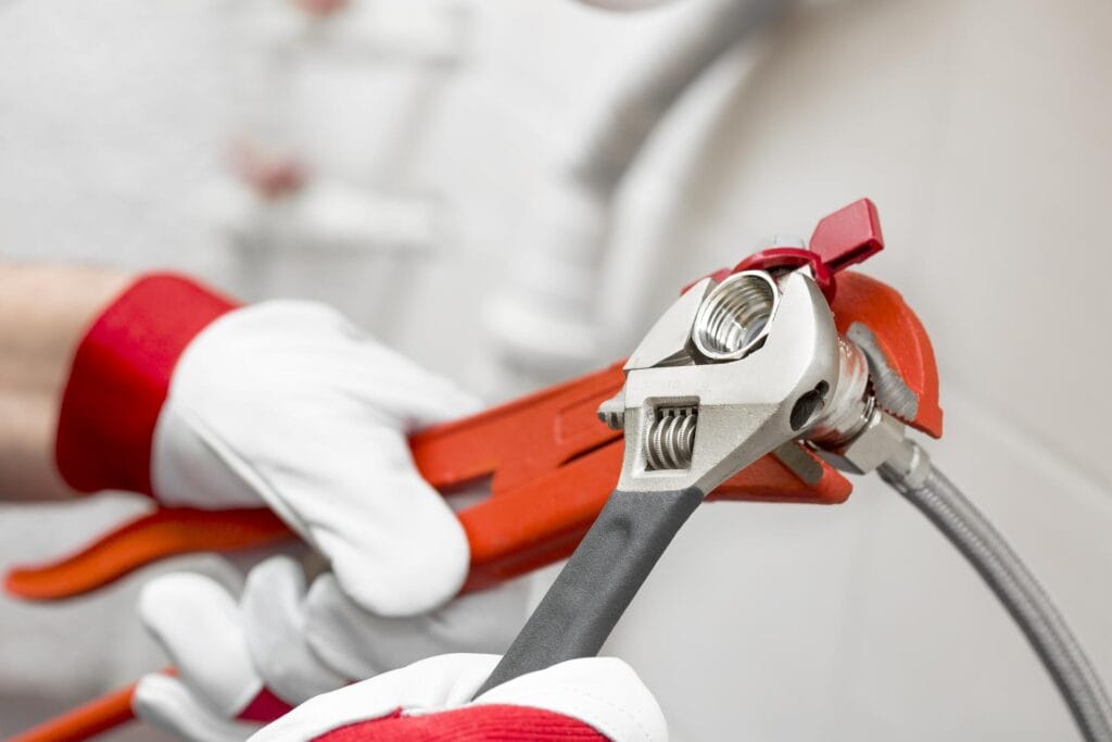 Plumber holding pipe wrenches for an emergency repair in Sun City Center