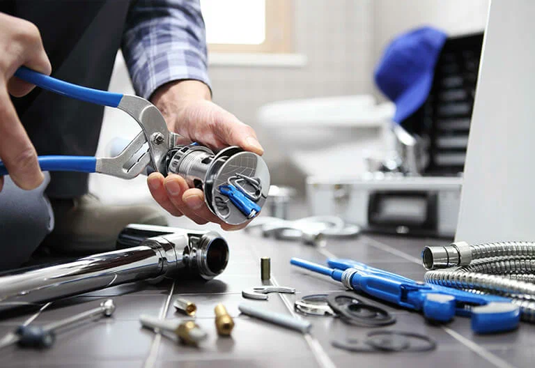 Technician repairing a plumbing fixture with professional tools in Sun City Center
