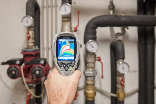 Plumber using a thermal imaging camera to inspect pipes in Sun City Center
