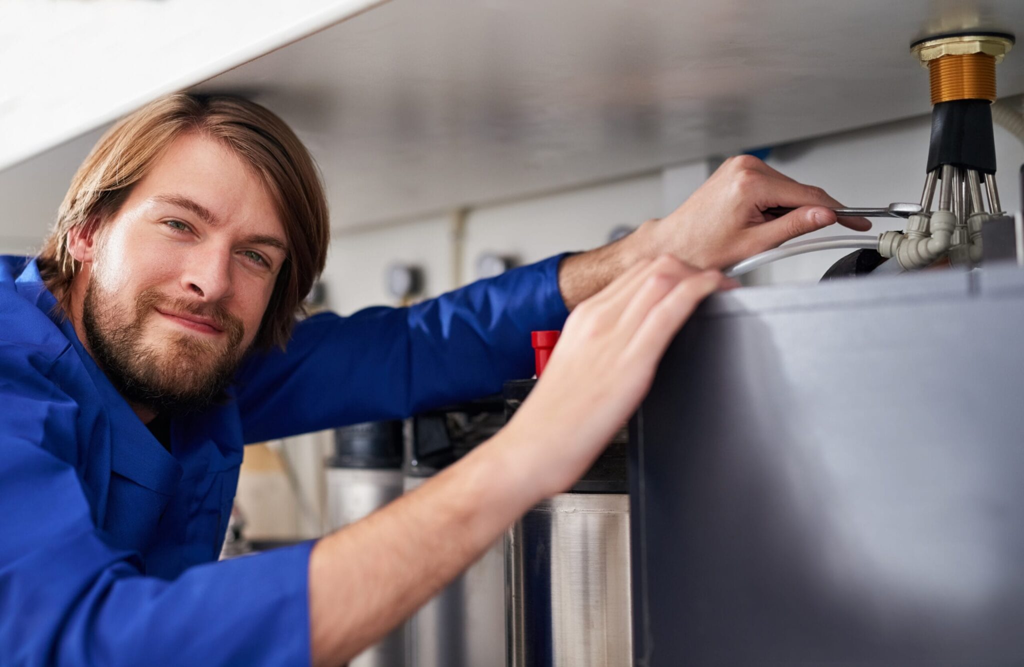 Technician servicing a residential water heater tank in Sun City Center